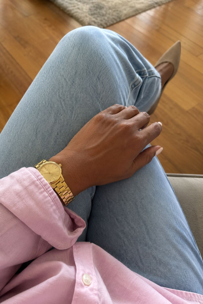 Everyday accessories featuring a gold wristwatch paired with light-wash denim and a pink button-down shirt