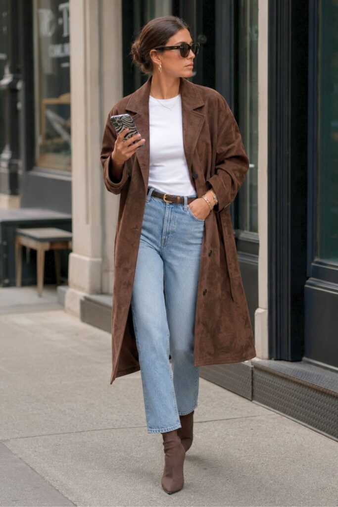 Woman wearing light blue straight-leg jeans with a white T-shirt, chocolate brown suede coat and brown ankle boots for a chic everyday outfit